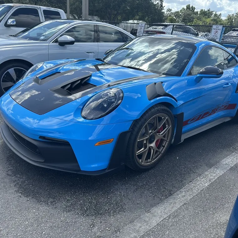 A blue Porsche 911 with tinted windows parked outside
