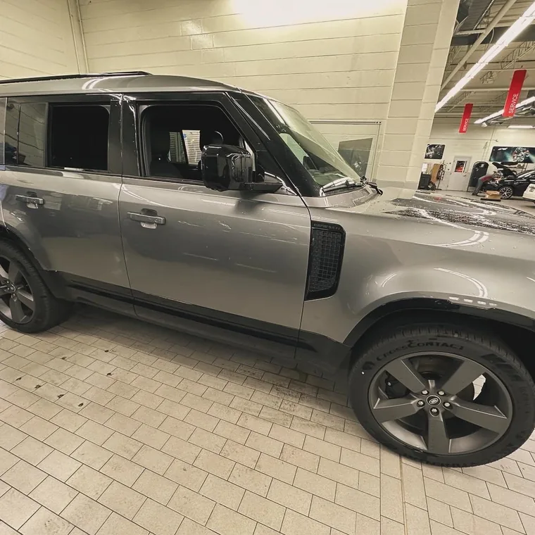 A grey Land Rover Defender with tinted windows