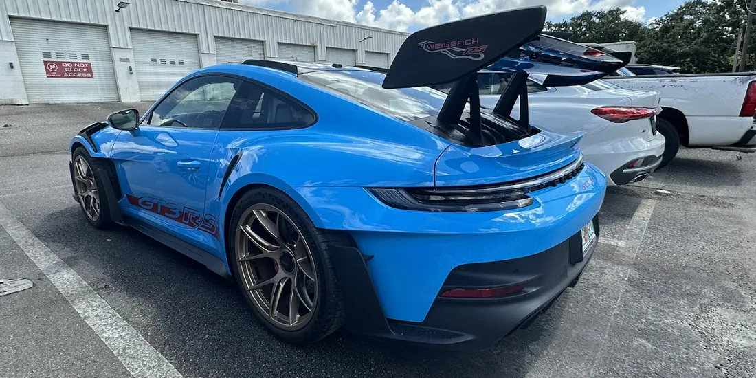 A blue Porsche 911 GT3 RS parked outside the shop