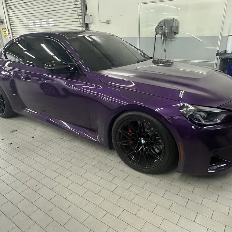 A purple BMW M2 with tinted windows