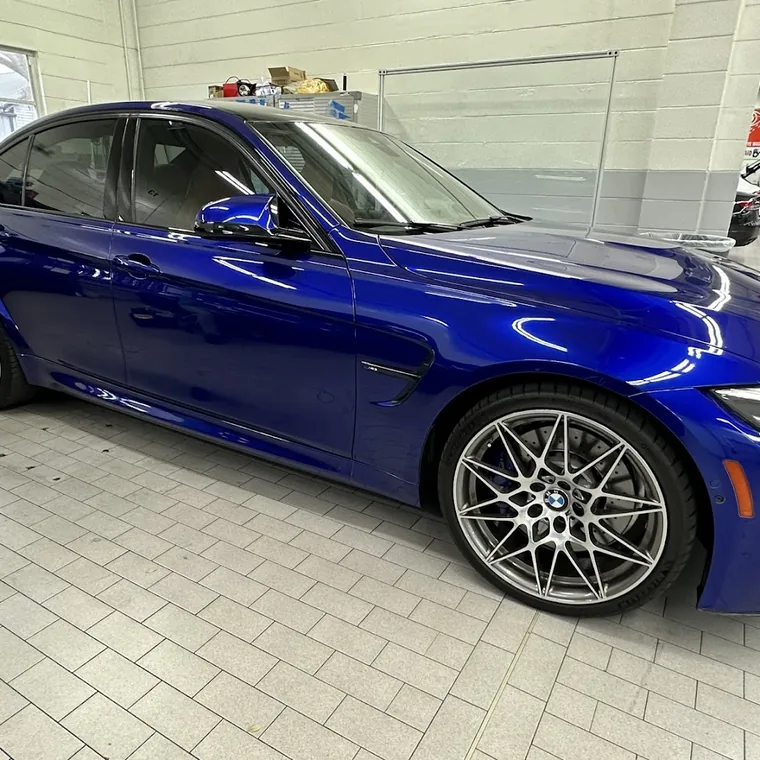 A blue BMW M3 with tinted windows