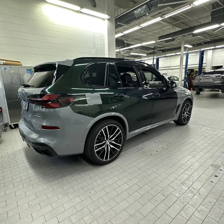 A dark green BMW X5 with tinted windows